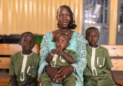 A woman with her three children sitting in a waiting area at a health centre.