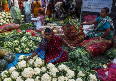 Women arranging vegetables to sell at a market in India