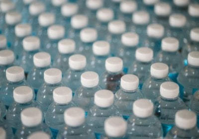 An image of many water bottles with white lids