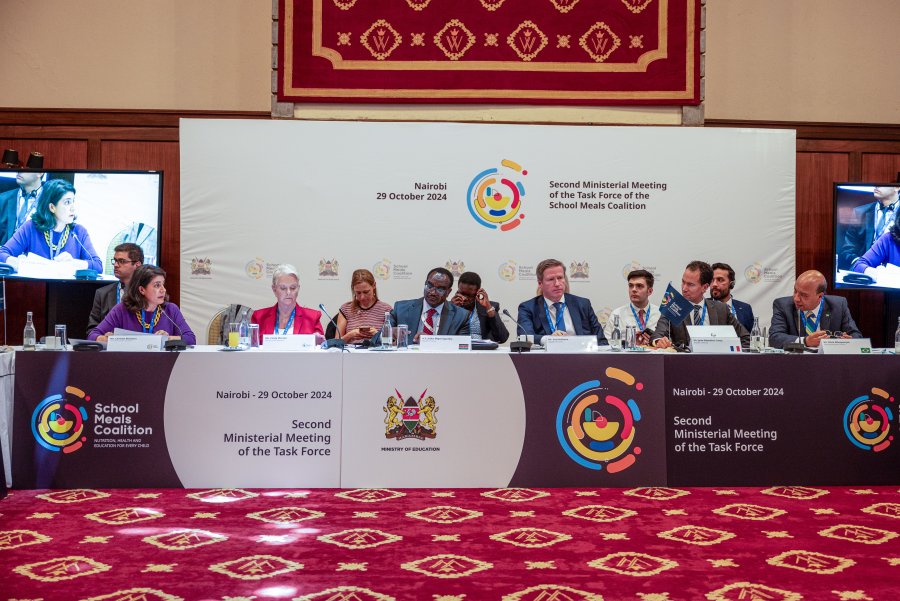 men and women in suits sit at table branded for the school meals coalition