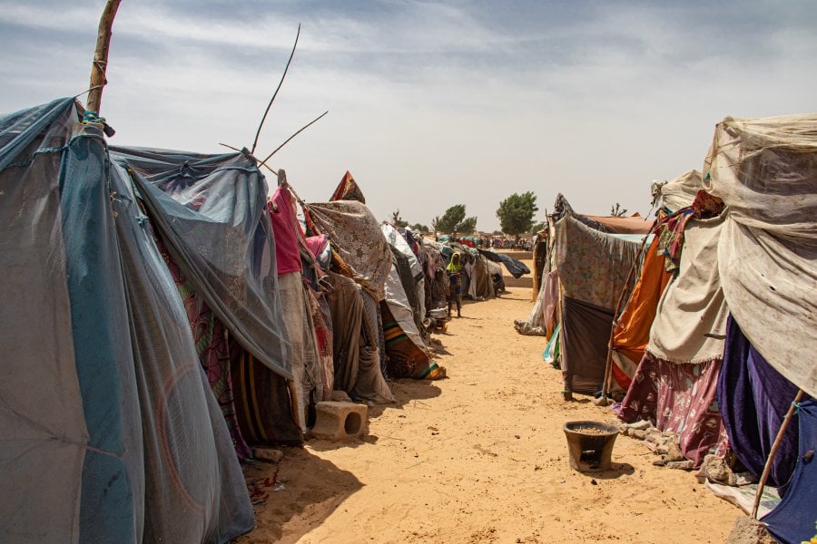 Two rows of make-shift tents on a desert floor