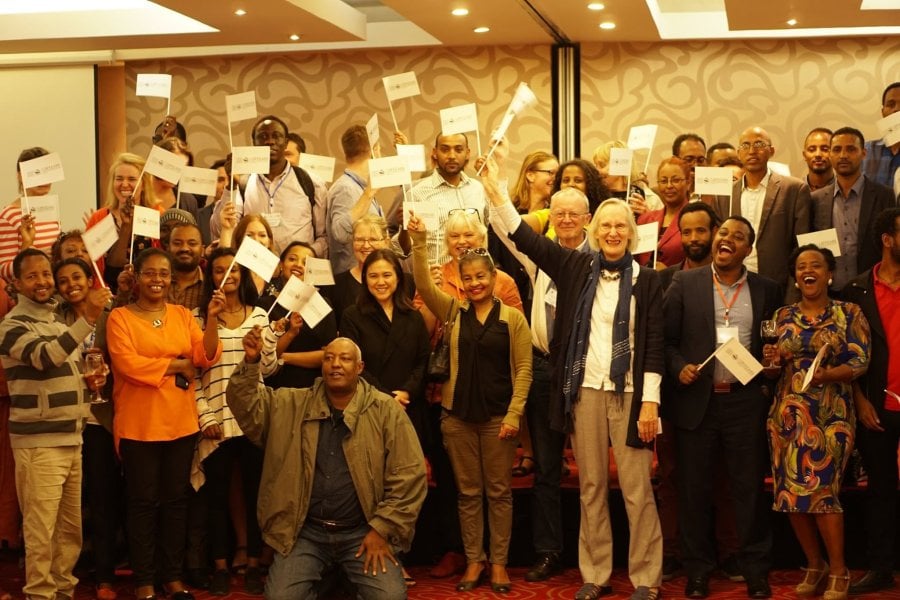 Group of LSHTM alumni in Ethiopia, holding LSHTM flags