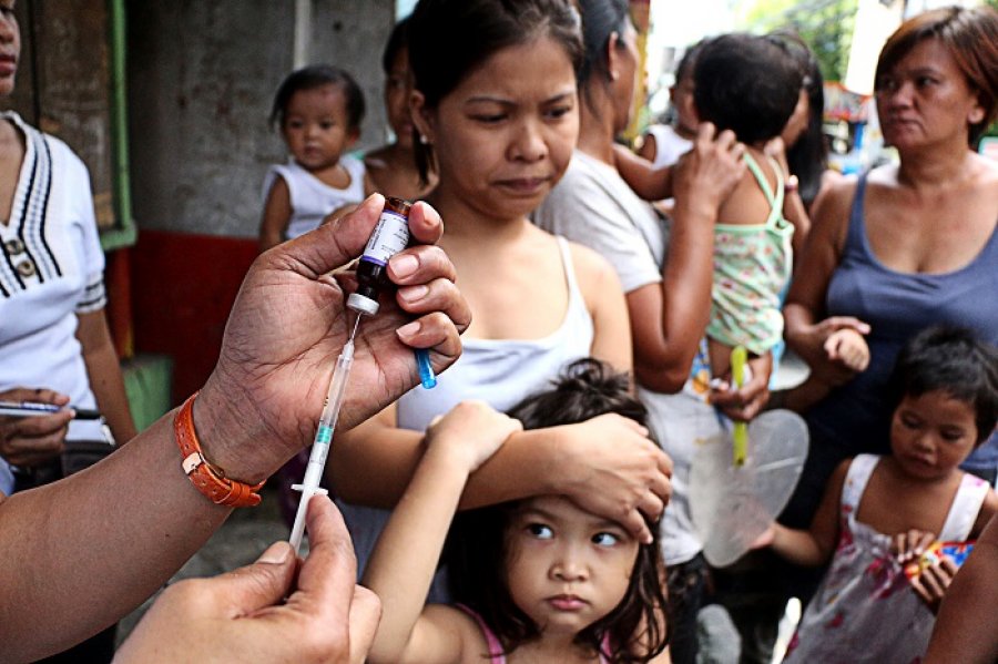 Caption: A city health worker prepares to vaccinate a young girl against polio and measles during free home visits for vaccination month in Mandaluyong City, Philippines. Credit: © 2014 Gregorio, Jr. Dantes, Courtesy of Photoshare