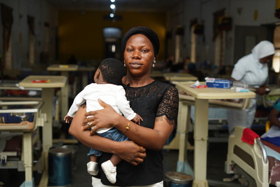 Woman holding a baby in a school setting