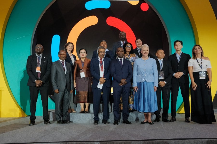 Group of men and women in suits on a stage in front of an SMC logo