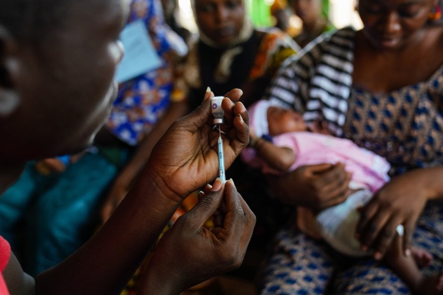 A clinician prepares a dose of vaccine at a Hospital