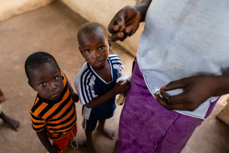Two young boys wait to be given their does of anti-malarials, Basse, The Gambia. Credit: Louis Leeson/LSHTM