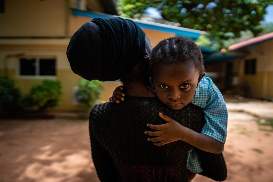 A woman carrying a child on her soulder