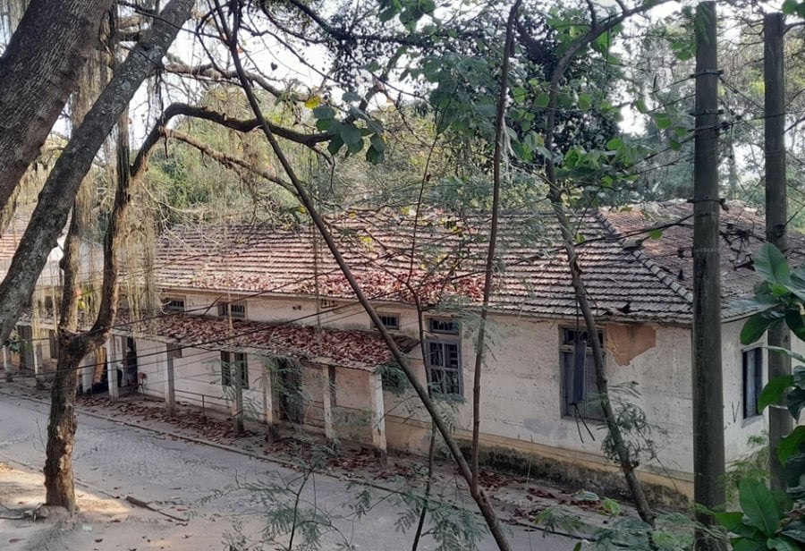 Hospital Curupaiti, a former leprosy colony located Jacarepaguá́, Rio de Janeiro. Photograph shows the dilapidated building set back amongst trees and shrubs