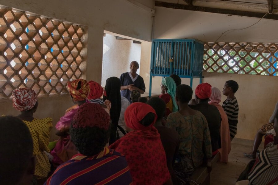 A male nurse is delivering health education to clinic attendees, Uganda