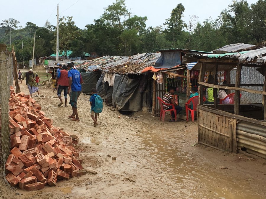 people walking in mud in rohingya camp