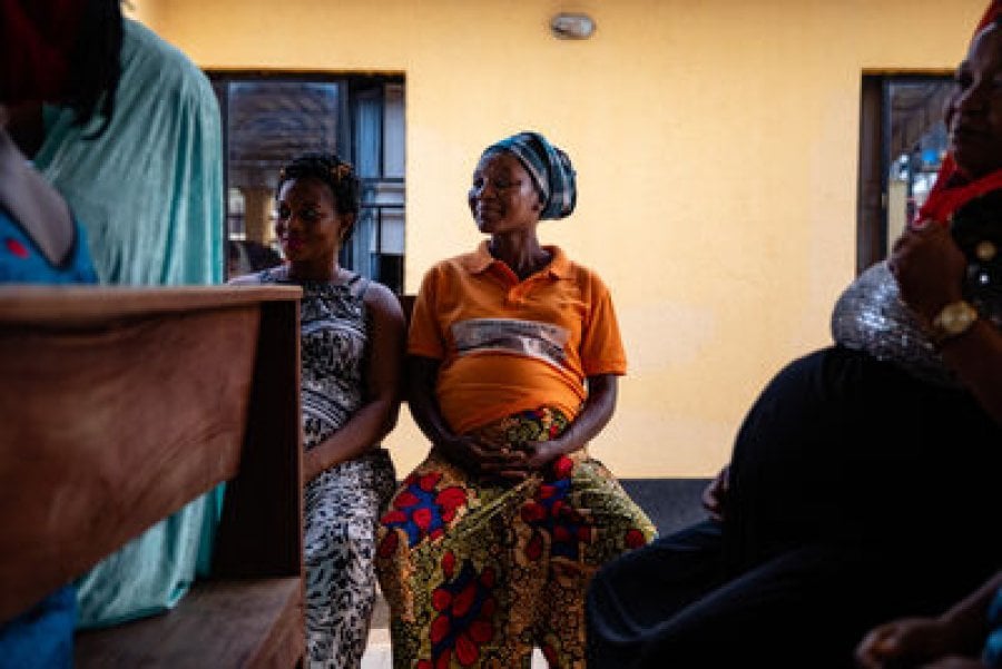 Pregnant women chat on benches while they wait to be seen by the nurse at the local Kuchigoro Primary Health Centre, Abuja.