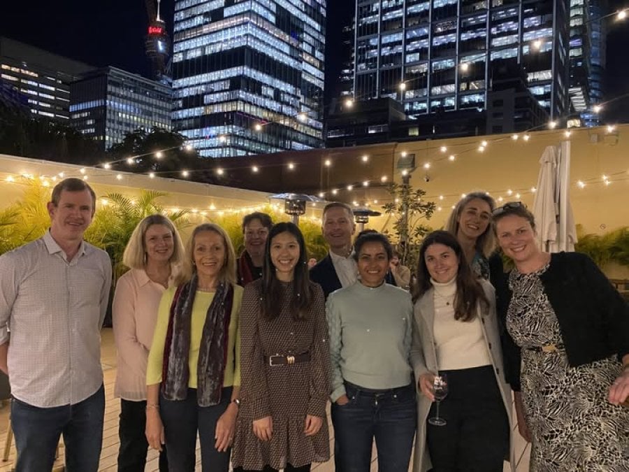 Group of alumni standing together at night time