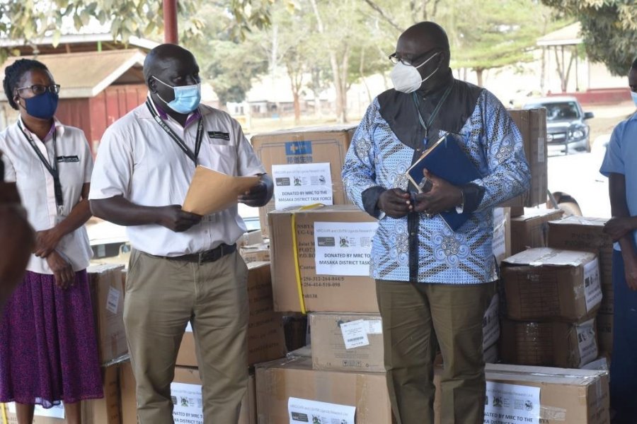 Dr. Freddie Kibengo (L), Head of the Unit station at Masaka hands over an assortment of PPE to Mr. Asporo Taremwa, Deputy Resident City Commissioner (RCC) Masaka City and a member of the Masaka District COVID-19 taskforce.