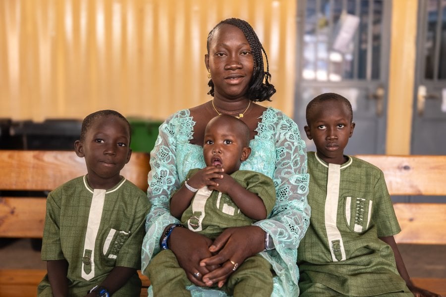 A woman with her three children sitting in a waiting area at a health centre.