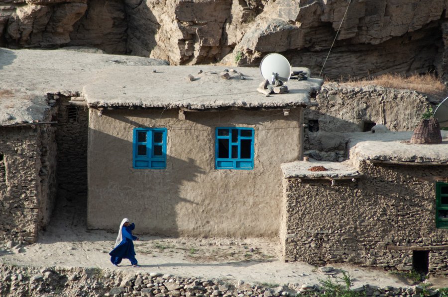 Woman walking in front of houses in Badakhshan, Afghanistan - Joel Heard on Unsplash
