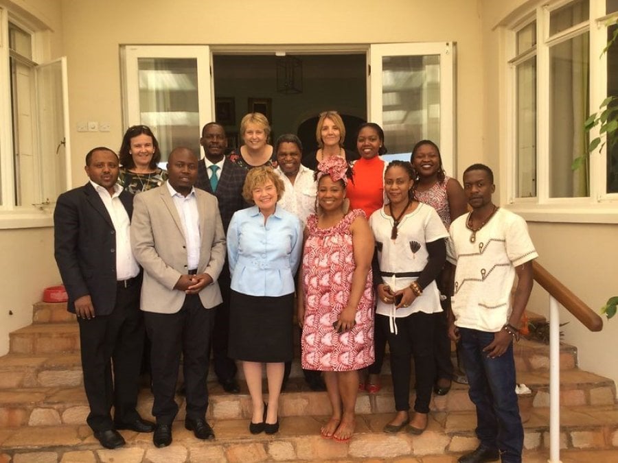 A group of LSHTM Alumni standing on steps at an alumni event