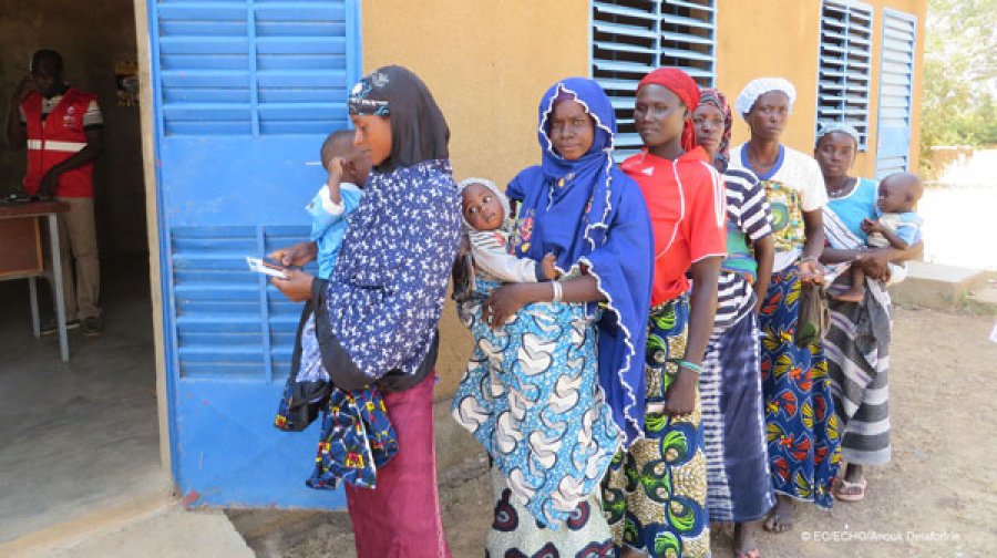 Women standing outside a health centre with their babies