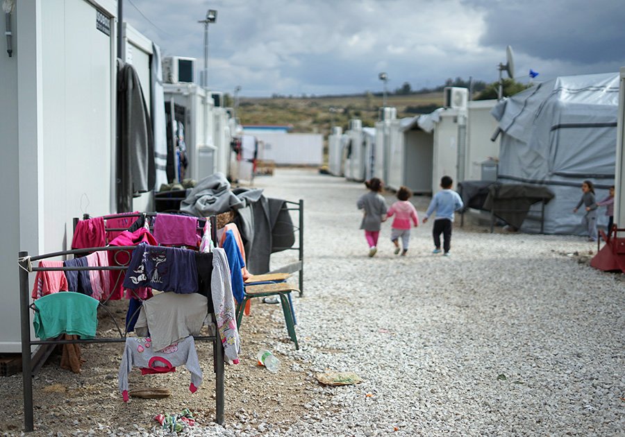 Group of children walking through a refugee camp in Greece. Photo by Julie Ricard on Unsplash