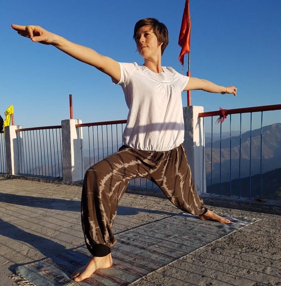 Image of a woman in a yoga pose with mountains behind