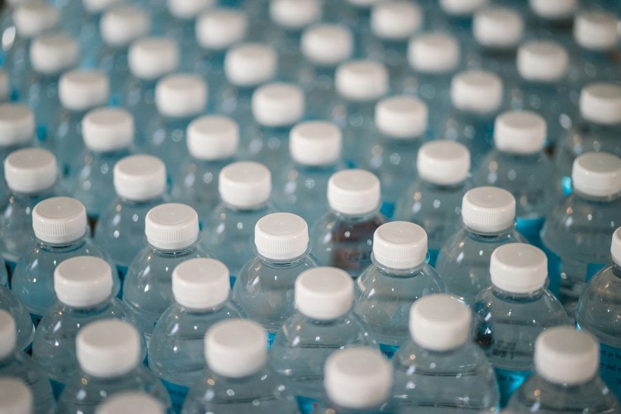An image of many water bottles with white lids