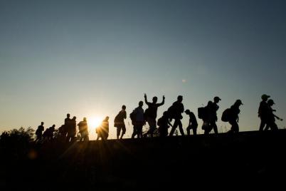 Migrants walking by sun