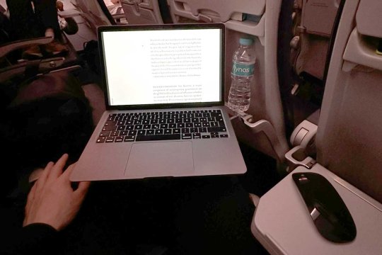 Simon working on his laptop on flight