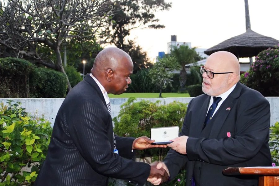 Pierre Gomez receiving the MBE medal from David Belgrove, British High Commissioner
