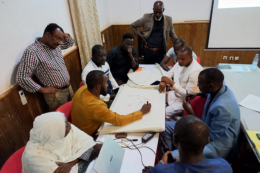 A group of people around a table in the workshop led by Dr Michel Dione in Senegal