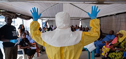 Dr Abdulmajid Suleiman Musa shows a group of Nigeria Centre for Disease Control staff how a correctly prepared PPE suit should look when working in a virus hit region, Keffi, Nasarawa stat, Nigeria 2019. Credit: Louis Leeson for LSHTM / UK Public Health Rapid Support Team