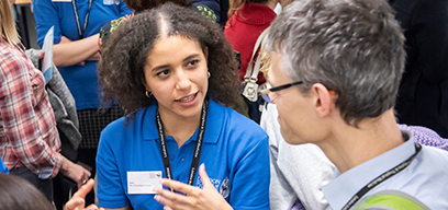 Student ambassador speaking with person at an event.