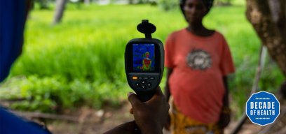 A thermal imaging camera measures the temperature of a woman and her unborn baby in The Gambia. Creidt: Louis Leeson. 