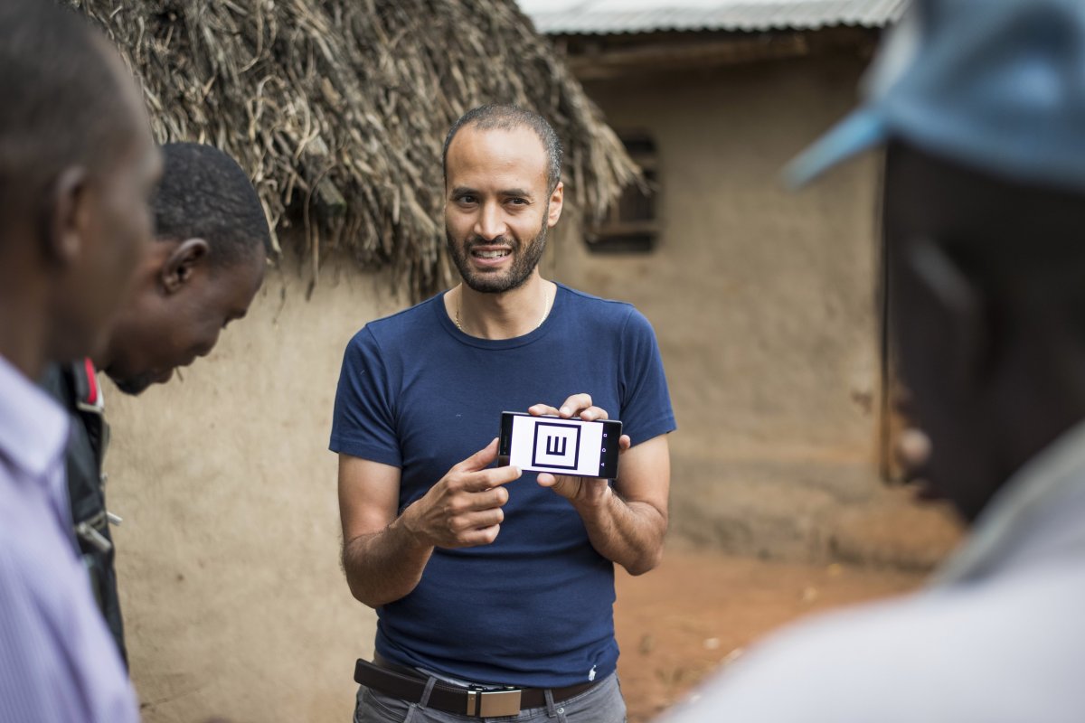 Dr Andrew Bastawrous uses Peek to check a Kenyan man's sight. Credit: Rolex / Joan Bardeletti